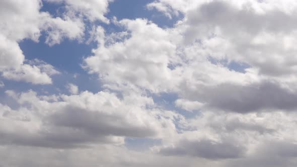 Watching the culumus clouds pass by overhead with patches of blue showing with some darker clouds.