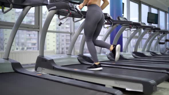 Young sporty Woman On Running Machine In Gym