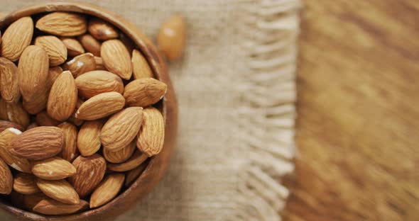 Video of almonds in a bowl on wooden background