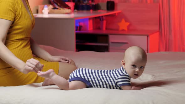 Happy little baby. Early baby development. Newborn. Happy infant. Mom does a foot massage