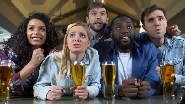 Young Multi-Racial Friends Rooting for Favorite Team, Watching Championship Pub