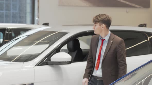 Mature Man Examining Cars on Sale at Dealership Salon