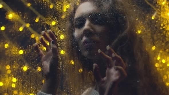 Girl Looking through Wet Window