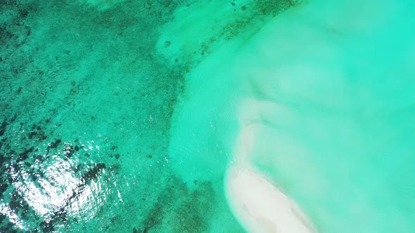 Natural birds eye copy space shot of a white sandy paradise beach and aqua turquoise water backgroun