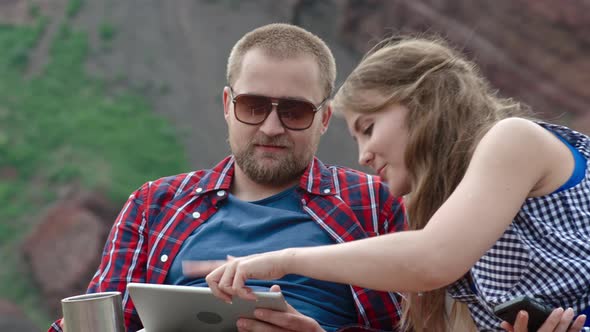 Couple Playing on Tablet on Camping Trip