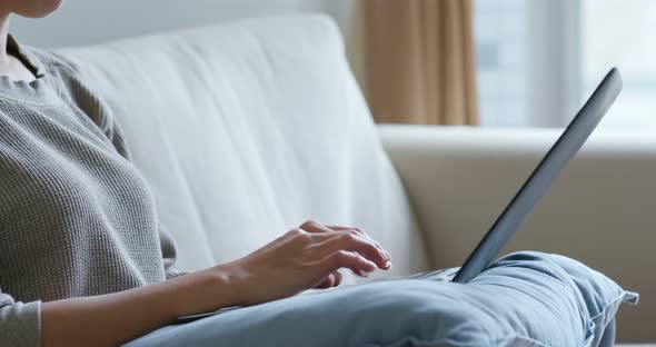 Woman type on notebook computer at home