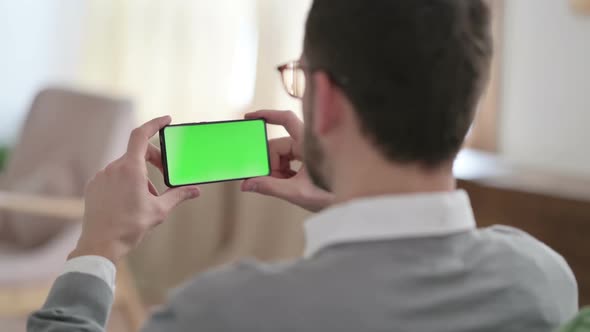Rear View of Man Watching Smartphone with Chroma Key Screen