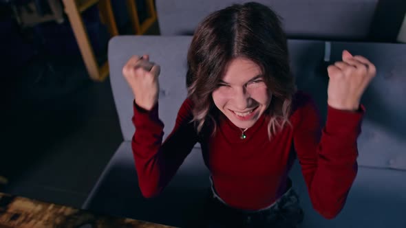 Woman Sitting at a Table and Rejoices