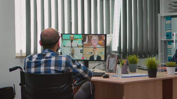 Manager in Wheelchair Talking with Mask During Videocall