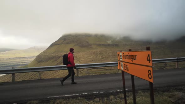 Hiker Passing Road Signs On Vidareidi
