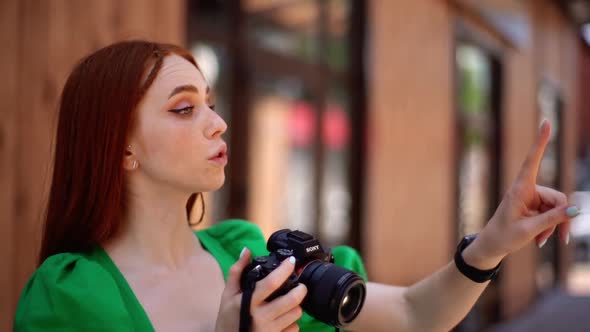 Closeup of Attractive Woman Photographer Taking Pictures with Professional Camera Instructs Clients