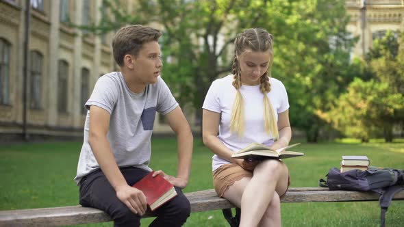 Teenagers Bored With Studies Having Conversation, Exhausted From Reading Books