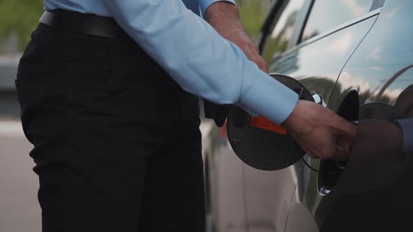 American Businessman Open Gas Tank Standing Near Black Car in City Street