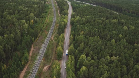 Sky View of Summer Road with Cars and Trucks. Summer Forest and Highway Road Drone View. Aerial