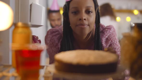 View From Inside Fridge of Young Woman Taking Cake From Shelf Having Birthday Party