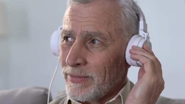 Aged Male in Headphones Listening to Music, Moving in Rhythm, Modern Style