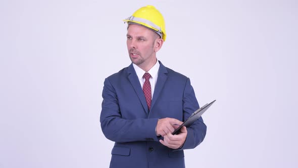 Happy Businessman As Engineer Directing While Holding Clipboard