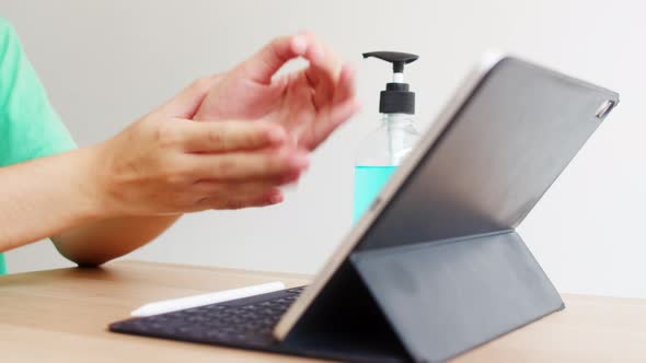 Asian woman using alcohol gel sanitizer wash hand before using tablet for protect coronavirus.