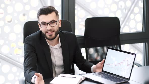 Handsome Young Man Working at Office Desk with Laptop