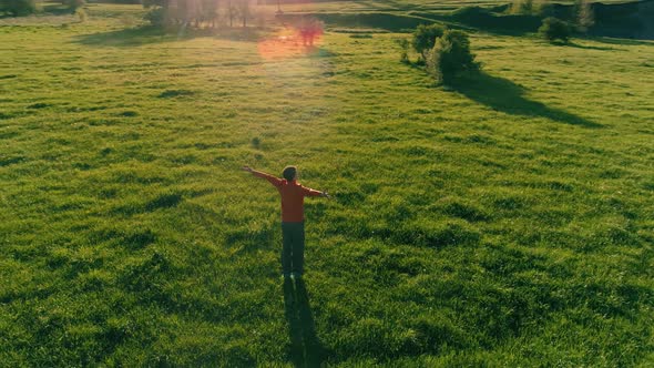 Low Altitude Radial Flight Over Sport Yoga Man at Perfect Green Grass. Sunset in Mountain.