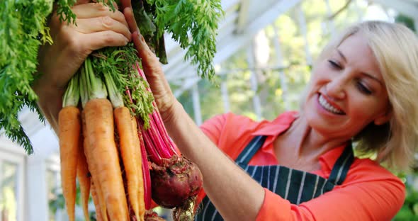 Mature woman holding bunch of vegetables