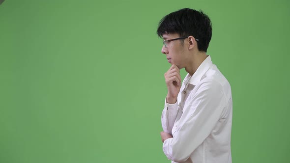Profile View of Young Asian Businessman Thinking