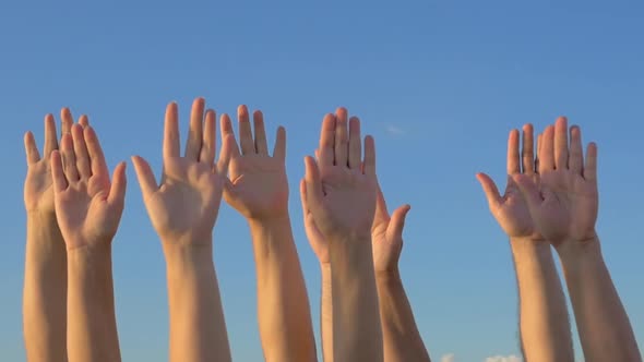 Hands up on blue sky background