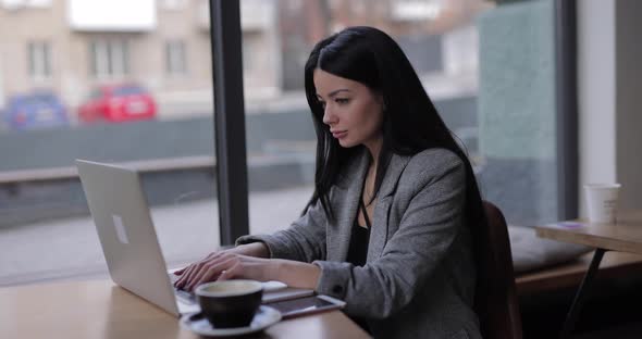 Freelancer Woman Works By Laptop PC in Cafe