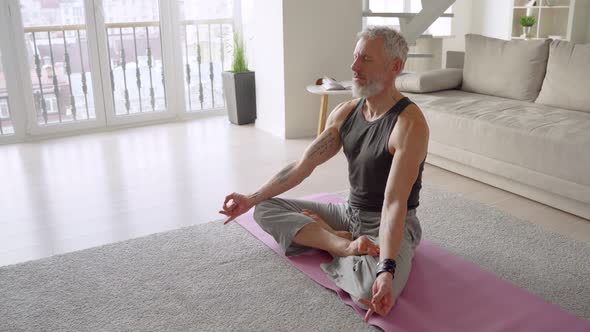 Strong Healthy Middle Aged Tattooed Man Doing Yoga Exercises at Home