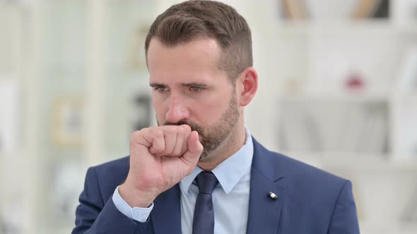 Portrait of Sick Businessman Coughing at Work