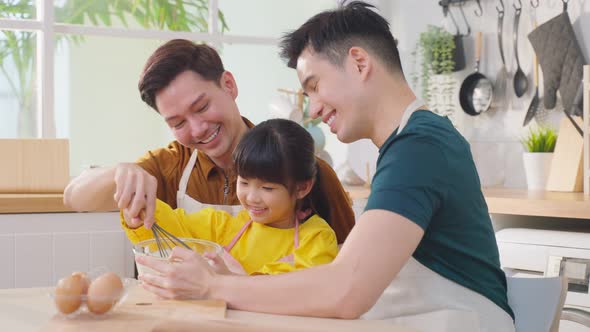 Asian attractive LGBTQ gay family feel enjoyment and teach girl kid making yeast dough.