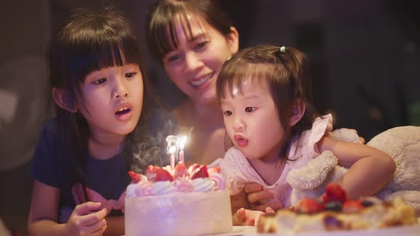 Asian happy young family have birthday party for young little child together at home. Lovely moment.