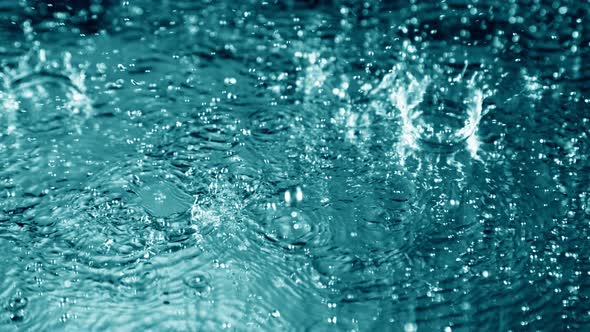 Super Slow Motion Shot of Many Water Drops Falling and Splashing on Surface at 1000Fps alt