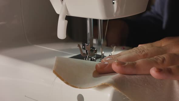 Womans hands using a sewing machine.