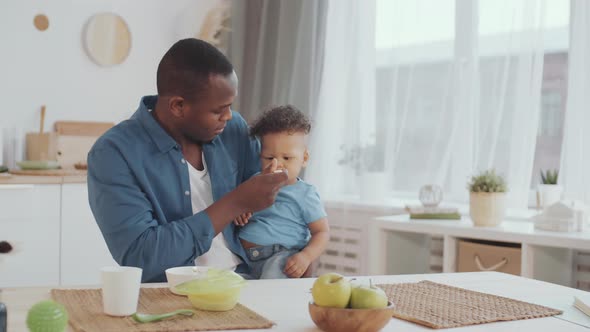 Man Feeding Toddler