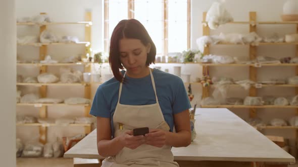 Young female potter working in her studio