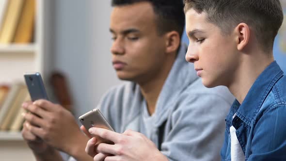 Two High School Boys Browsing Social Media Site on Smartphones, Mobile Addiction