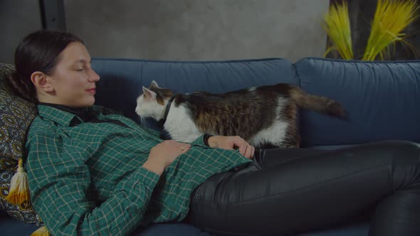 Female Pet Owner Bonding with One Eyed Cat on Sofa