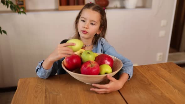 Little Happy Girl Hold Bowl with Fruits in the Kitchen at Home Healthy Child Snack