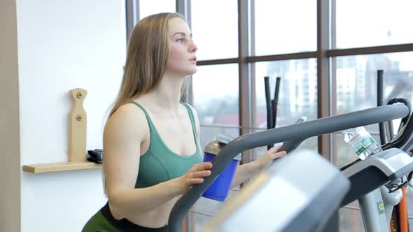 Attractive Sports Girl on a Treadmill