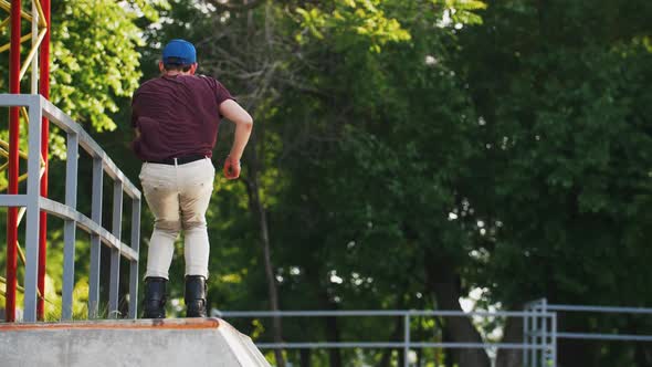 Aggressive Inline Roller Skater Doing Tricks in Concrete Skatepark Outdoors with Beautiful