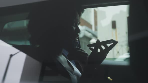 African american woman wearing face mask in car