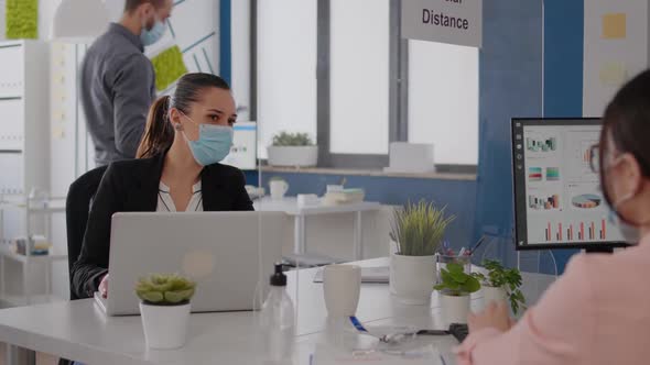 Business Team with Medical Face Masks Working Together in Startup Company Office