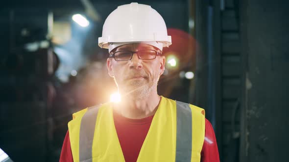 Engineer Looking Straight and Smiling in the Light Beam