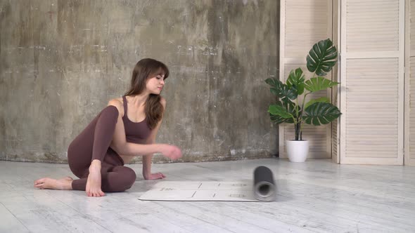 Woman unrolls yoga mat