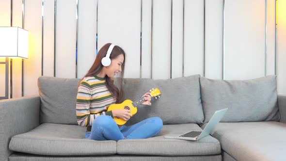 Young asian woman play ukulele