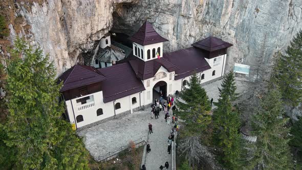 Aerial drone view of The Ialomitei Cave in Romania. Entrance into the cave with tourists in Bucegi M