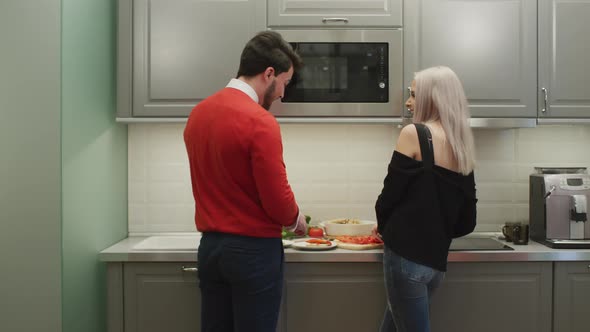 Couple laughs and talks in the kitchen