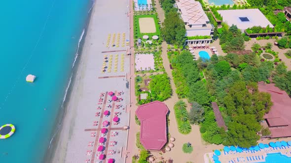 Drone view of the hotel grounds, pool, beach and sea.