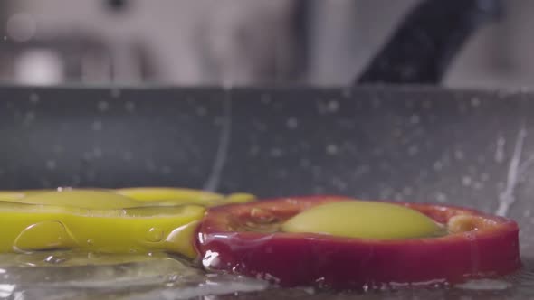 Falling of the Eggs Into the Sweet Pepper on the Frying Pan, Slow Motion